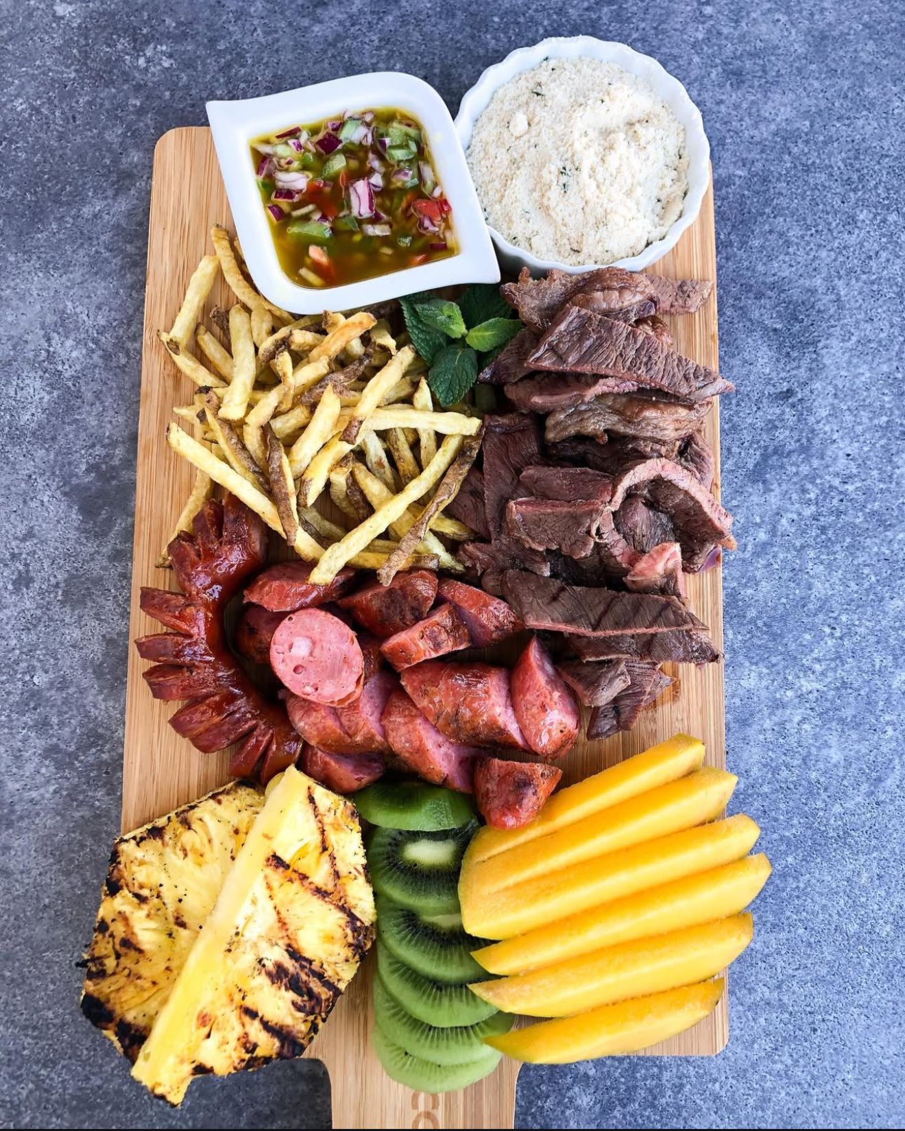 Traditional meat board with chimichurri and sides