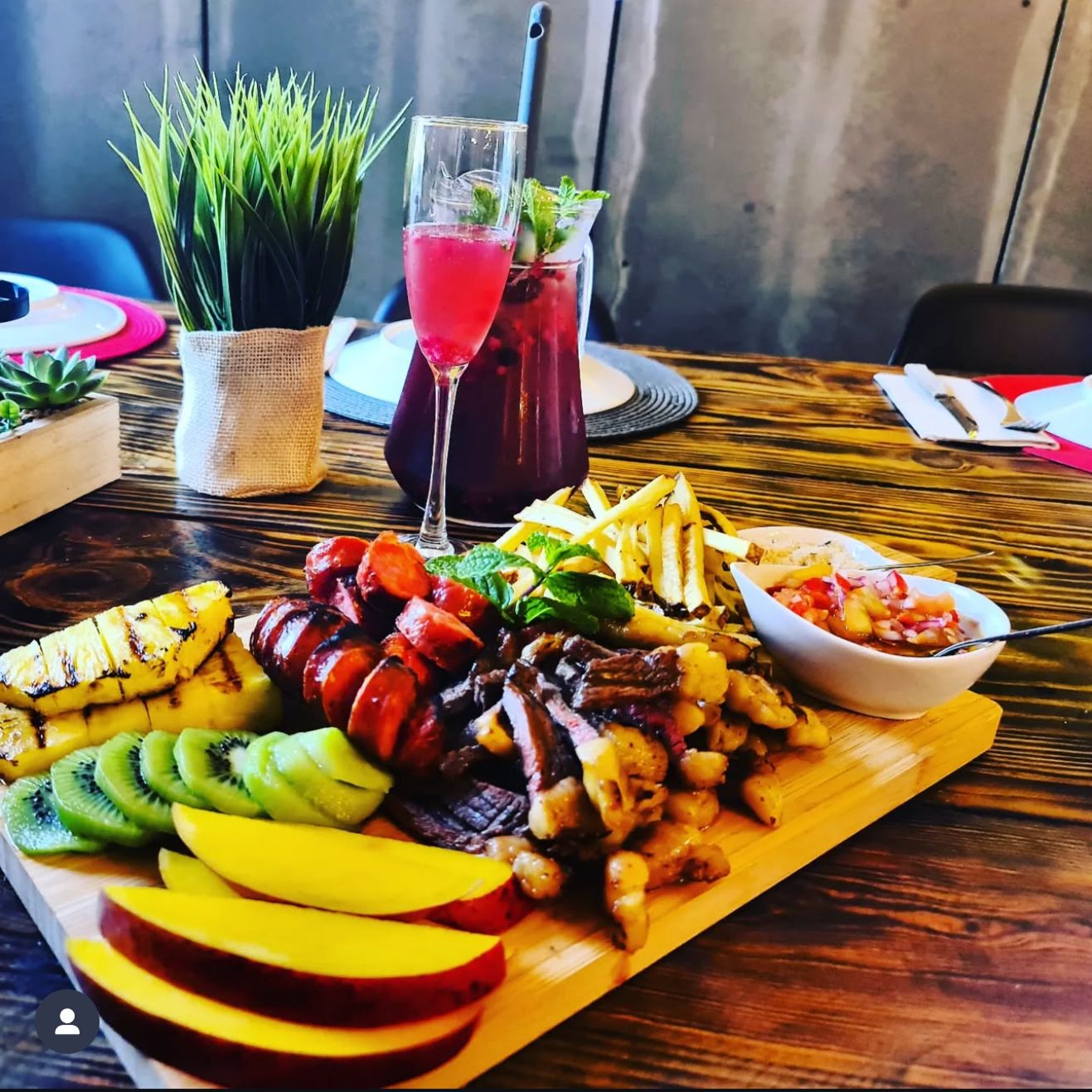 Colorful meat and fruit platter with cocktails